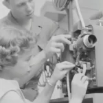 two people operating an old fashioned film camera - media