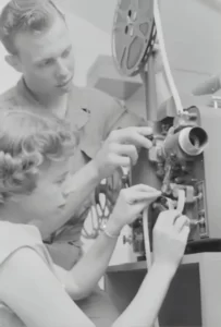 two people operating an old fashioned film camera - media