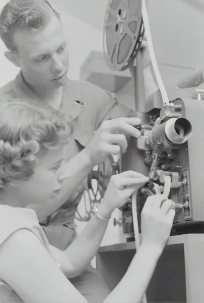 two people operating an old fashioned film camera - media