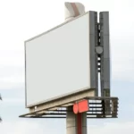 A blank billboard next to a palm tree