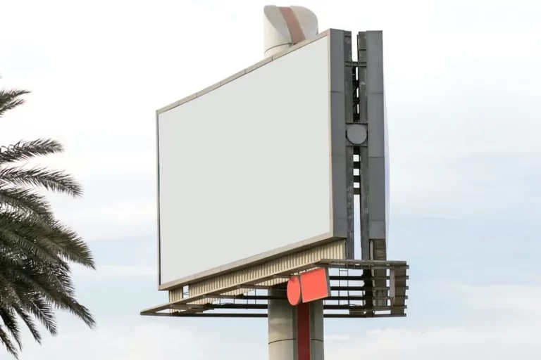 A blank billboard next to a palm tree