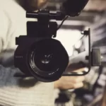 A man setting up a camera for film