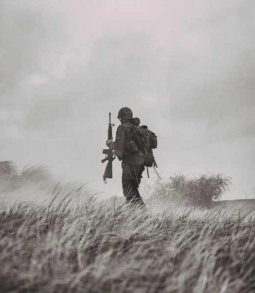 a black and white shot of a lone soldier walking across the tundra