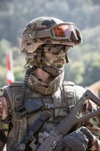 A close up of a soldier wearing sunglasses and carrying a gun