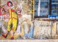 a graffitti image on a wall of ronald mcdonald - capitalism