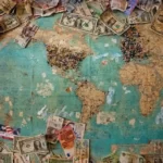A map of the world with dollar bills surrounding it