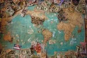 A map of the world with dollar bills surrounding it