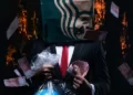 A man in a suit holding the world in a bag with one hand, a wad of cash in the other hand, and a starbucks bag over his head.