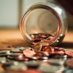 a coin jar tipped over - profit motive education
