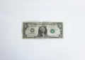 A one dollar bill against a grey background