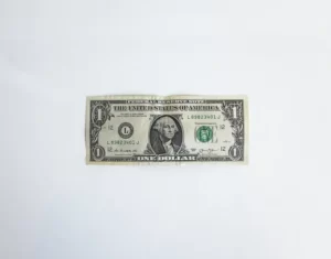 A one dollar bill against a grey background