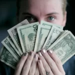 a man holding money in a fan shape - income earnings