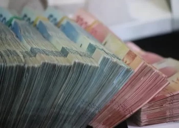 side-facing image of large bundles of cash in various denominations