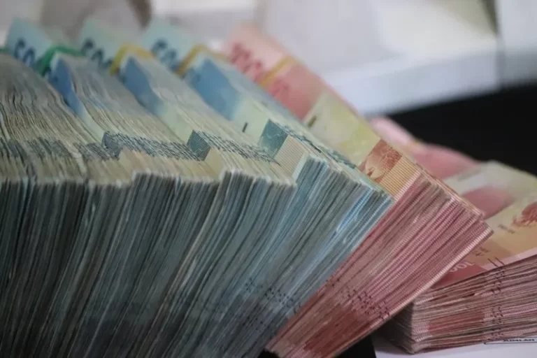 side-facing image of large bundles of cash in various denominations