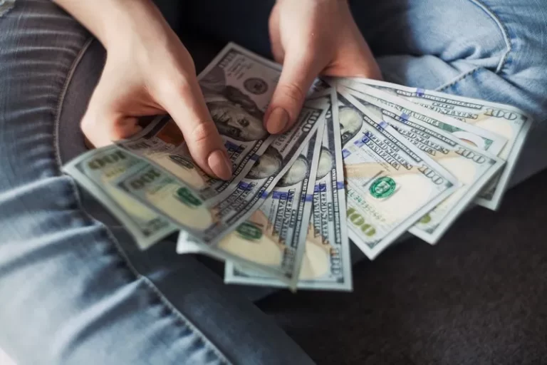 a person holding a fan of money income