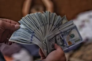 Somebody holding a fan of dollar bills - capital accumulation