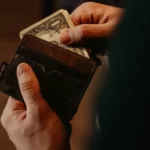 A man taking money out of his wallet private profit