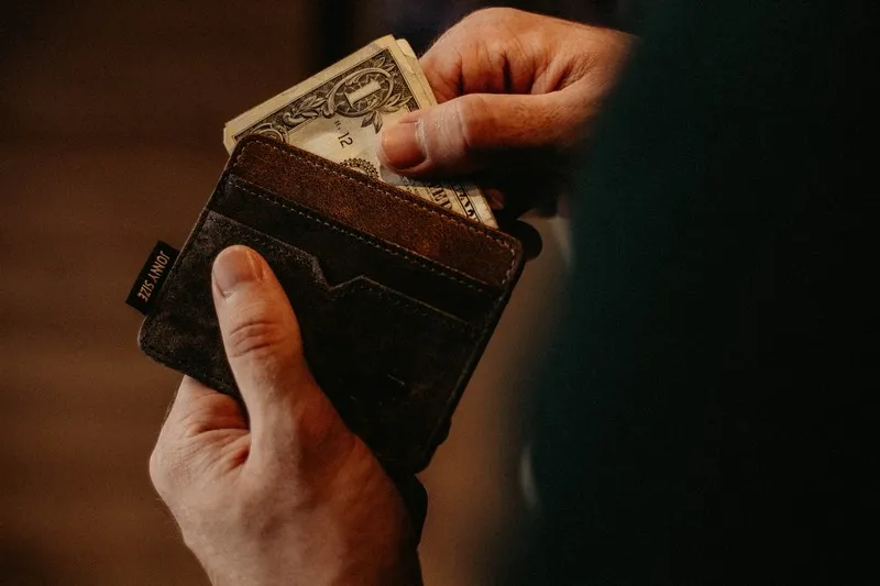 A man taking money out of his wallet private profit