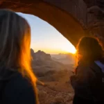two women stood in a cave at sunset - cultural values