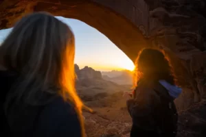 two women stood in a cave at sunset - cultural values