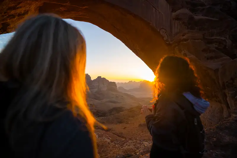 two women stood in a cave at sunset - cultural values