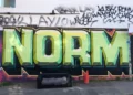 graffiti on a wall saying 'norms'