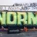 graffiti on a wall saying 'norms'
