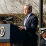 Geroge Dubya Bush talking at a lecturn democracy