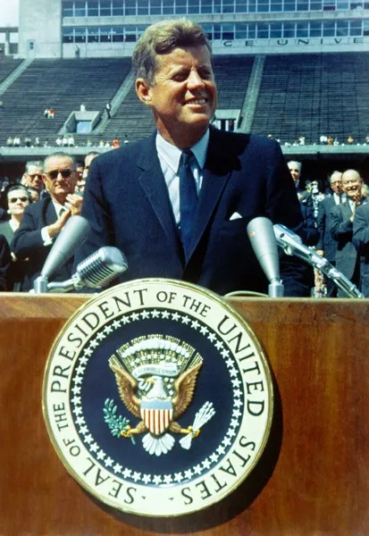 John F Kennedy giving a speech at a lectern democracy