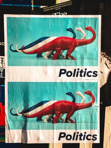 A poster with the word politics and 3 dinosaurs in red white and blue