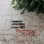 Graffitti on a wall stating 'politics'