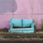 An old turquoise couch dumped in the street poverty welfare