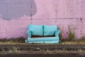 An old turquoise couch dumped in the street poverty welfare