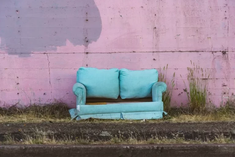 An old turquoise couch dumped in the street poverty welfare