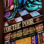 A stained glass window saying 'for the poor