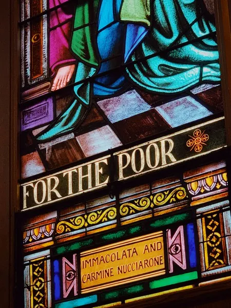 A stained glass window saying 'for the poor
