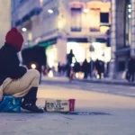 a person sat on the ground begging