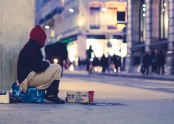 a person sat on the ground begging