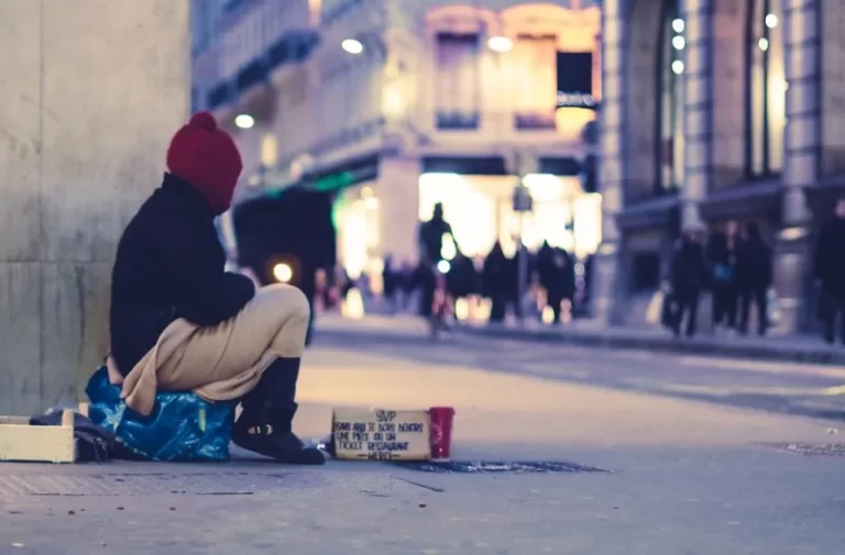 a person sat on the ground begging