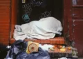 A homeless person in a doorway under a blanket ecperiencing stigmatisation