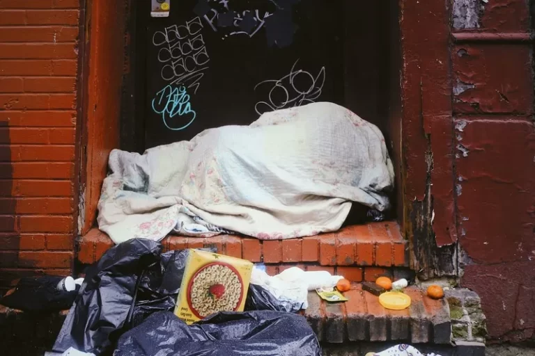 A homeless person in a doorway under a blanket ecperiencing stigmatisation