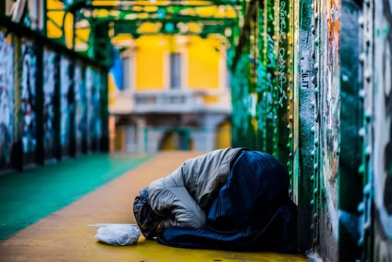 A person kneeling on the floor in poverty