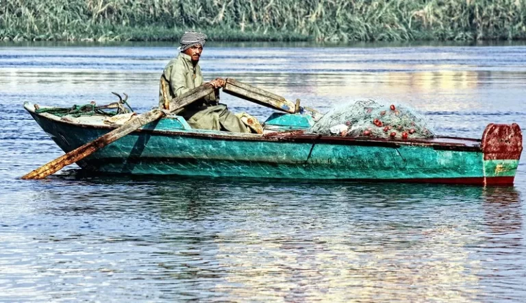 A poor fisherman in a green boat on the water