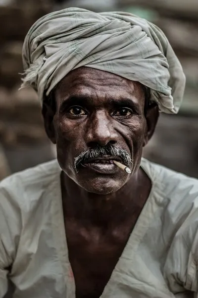 An asian man smoking a cigarette in poverty