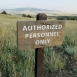 A wooden sign in a field statin 'authorized personnel only'