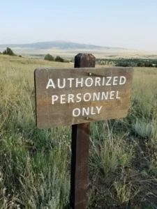 A wooden sign in a field statin 'authorized personnel only'