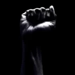 A raised fist against a black background