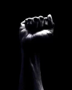 A raised fist against a black background