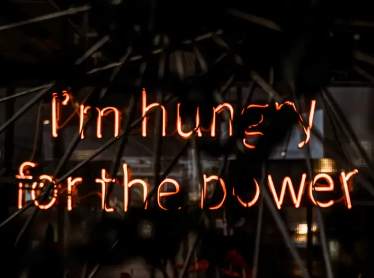 neon lights in fire colours - reads 'i'm hungry for the power'