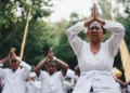 a group of people dressed in white kneeling and praying